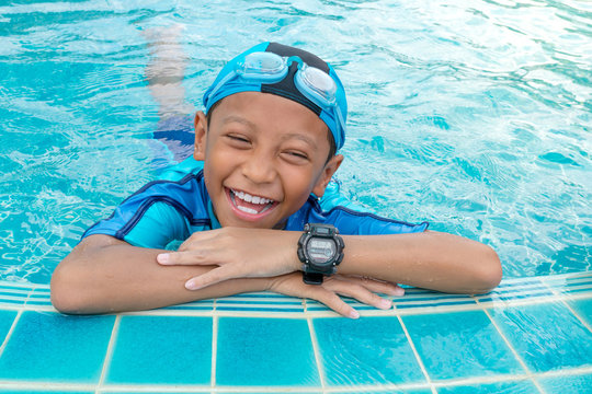 Portrait of a boy smiling in public swimming pool