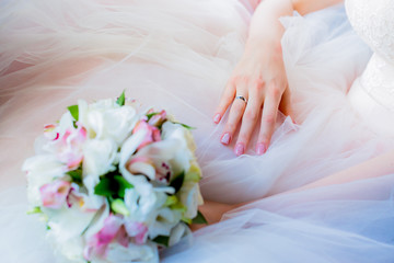 close up of bride with bouquet of flowers and wedding ring.