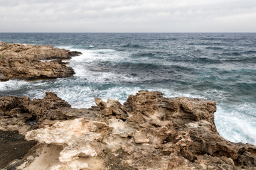 Mediterranean Sea waves breaking rocky coastline of Cyprus island