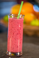 Fresh red smoothie with fruits on the background