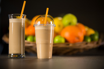 Fresh banana yogurt smoothie with fruits on a black background