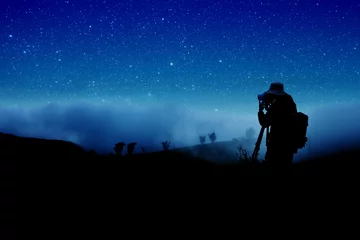 Poster silhouette of photographer shooting night stars © Siraphatphoto