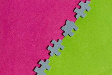 Jigsaw Puzzle pieces on pink and green background