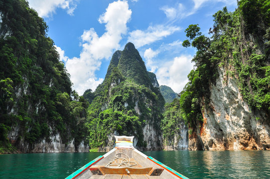 Fototapeta Huge limestone cliffs rising out of open lake at Khao Sok National Park, Ratchaprapha Dam in Surat Thani Province, Thailand.