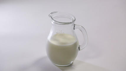 glass jug with milk on white background.