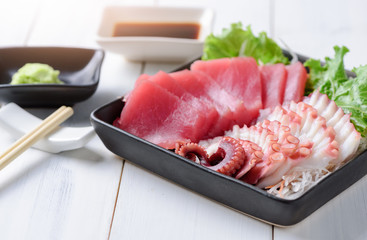 sashimi tuna and squid on wood background