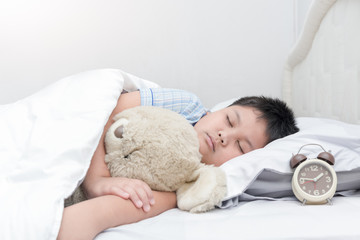 obese fat boy sleep and hug teddy bear on bed,