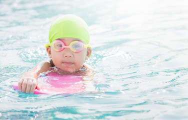 cute little girl learning how to swim.