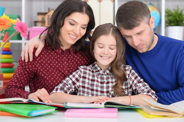 Obraz premium Parents helping daughter with lessons