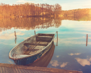 Small old wooden dinghy moored on a lake