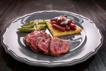 Sliced beef steak with grilled vegetables on a plate