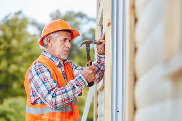 Senior als Handwerker arbeitet auf Baustelle