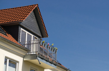 Giebel mit Balkon vor blauem Himmel in Kassel, Deutschland