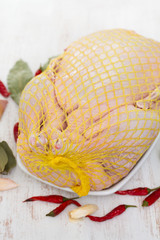 raw duck on dish on wooden background