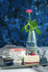 A cup of tea with lemon and pastries on a blue background. Breakfast. The concept of drinks and food.