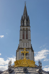 Fototapeta na wymiar The Upper Basilica with gilded crown ad cross in Lourdes