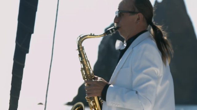 Talented saxophonist performs jazz on saxophone at yacht