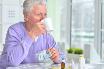Sick elderly man taking medicine
