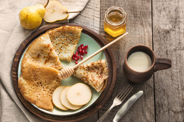 Tasty traditional russian breakfast of slapjack with honey on plate. Rustic style. Space for your text.