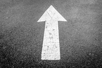 Isolated image of black tar pavement directional white arrow. White street sign arrow pointing up....