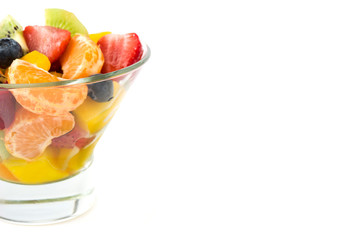 Fruit salad in crystal bowl isolated on white background
