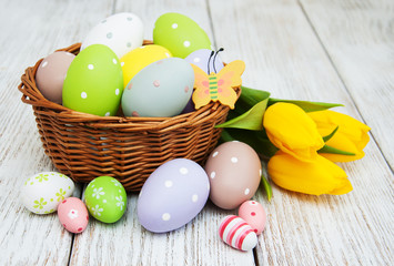Fototapeta na wymiar Basket with easter eggs and tulips