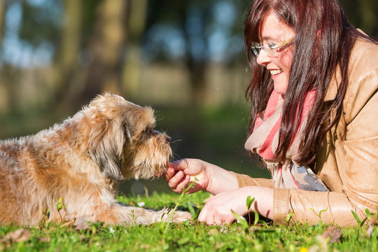 young woman gives her dog a treat
