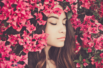 Fototapeta premium Beautiful young woman surrounded by flowers