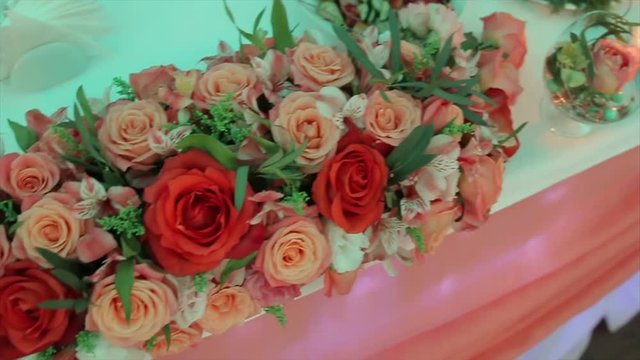 Decoration of wedding table with flowers. wedding flowers on the table. Artificial roses decorate the wedding table. bouquets on the occasion. Celebration