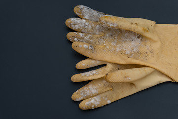 yellow moldy glove on a black background