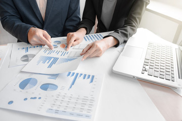 Business team two colleagues discussing financial graph data on office table with laptop5