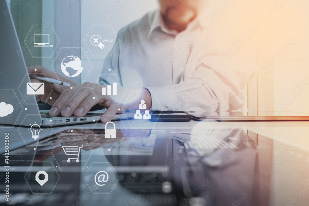 Poster businessman working with smart phone and laptop computer on wooden desk in modern office with virtua