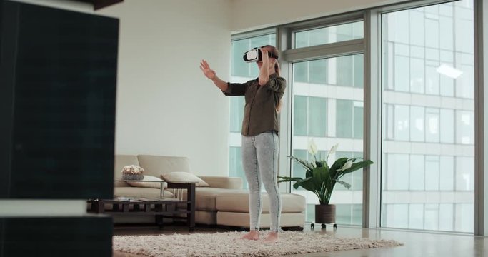 woman in VR virtual reality glasses in a modern living room