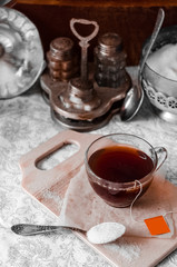 A bag of black tea with a spoon of sugar