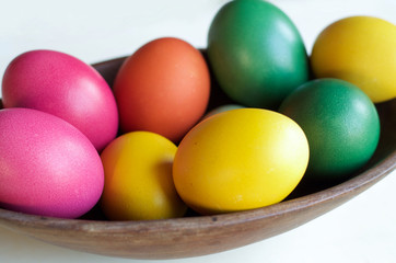 Obraz na płótnie Canvas colorful easter eggs in wooden bowl