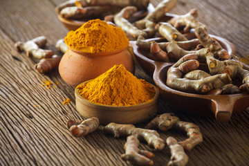 Turmeric roots on wooden background