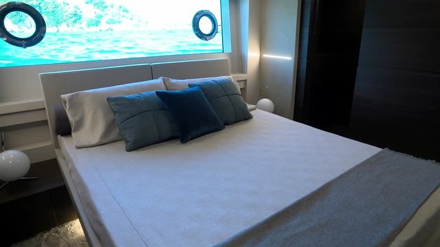Double bed in guest cabin of a luxury yacht.
