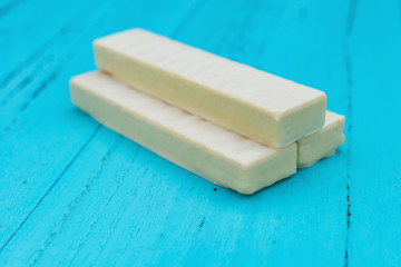side view white chocolate wafer with dish on a blue background