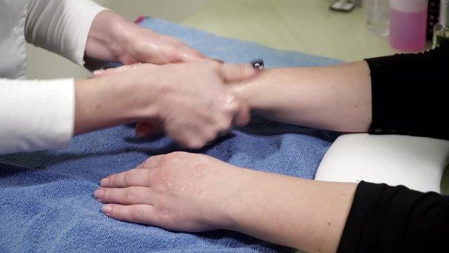 Beautician is applying creme to woman's hands