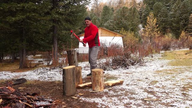 lumberman cutting wood with axe against beautiful Altai nature 