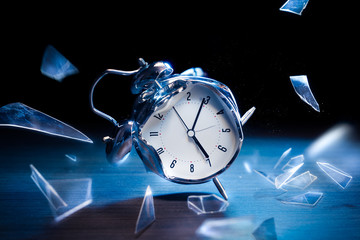 broken alarm clock with shattered glass on a dark background