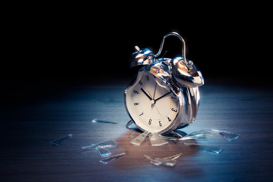 broken alarm clock with shattered glass on a dark background