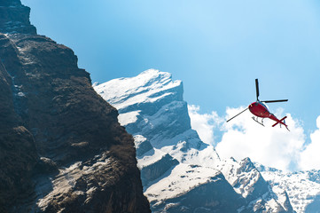 Red Helicopter flying near mountain peak - 142506995