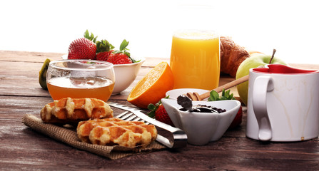 breakfast on table with waffles, croissants, coffe and juice