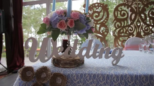 Wedding table at a wedding feast decorated with bridal bouquet. Banquet hall. festive table for the bride and groom decorated with cloth and flowers. Table set for bride and groom. Wedding