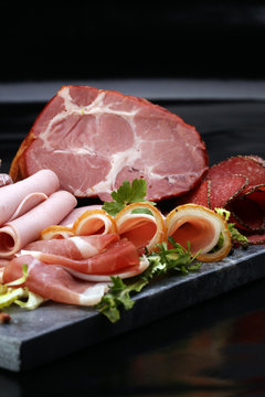 Food tray with delicious salami, pieces of sliced ham, sausage,