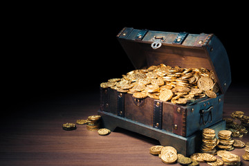Open treasure chest with gold coins on a dark background