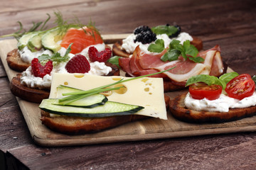 Bread Brushetta or authentic traditional spanish tapas set for lunch table. Sharing antipasti on party or summer picnic time over wooden rustic background.