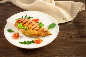 Grilled chicken fillet with cherry tomatoes and salad leaves