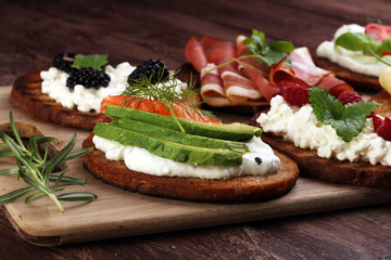 Bread Brushetta or authentic traditional spanish tapas set for lunch table. Sharing antipasti on party or summer picnic time over wooden rustic background.